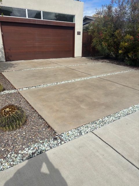 A driveway in front of a house with a brown garage door
