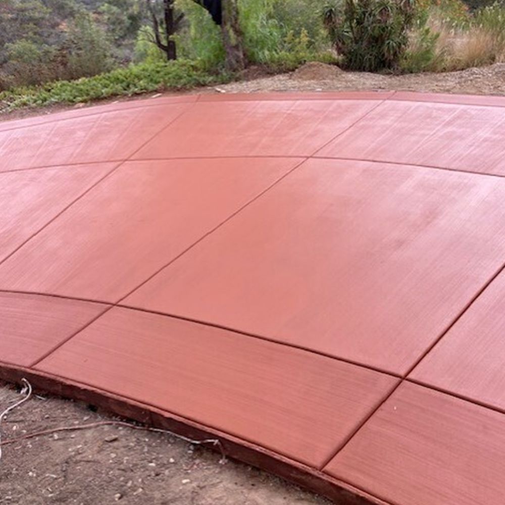 A red concrete driveway with a curve in the middle