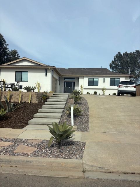 A white house with a car parked in front of it