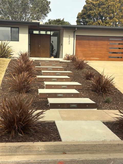 A house with a wooden garage door and steps leading up to it