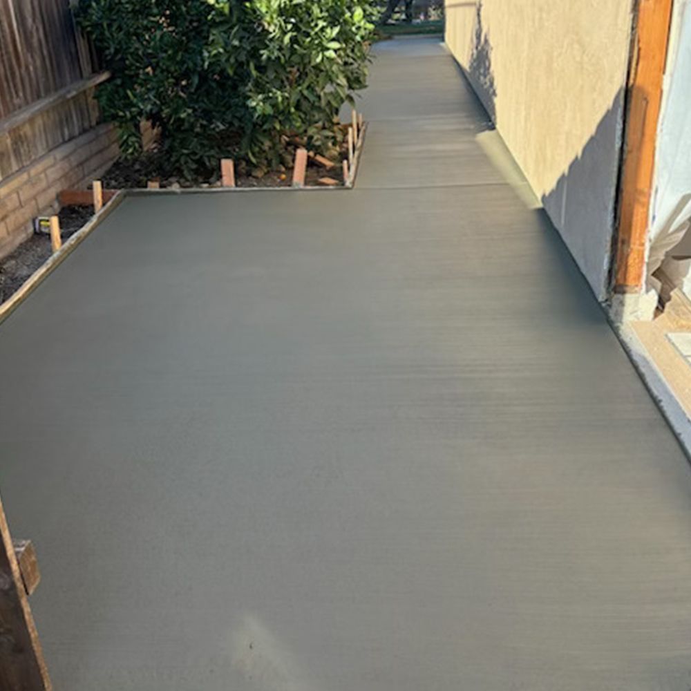 A concrete walkway is being built in front of a house.