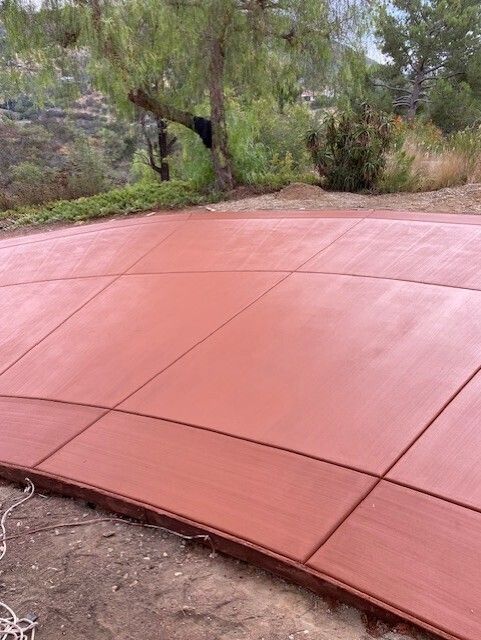 A red concrete walkway with trees in the background.