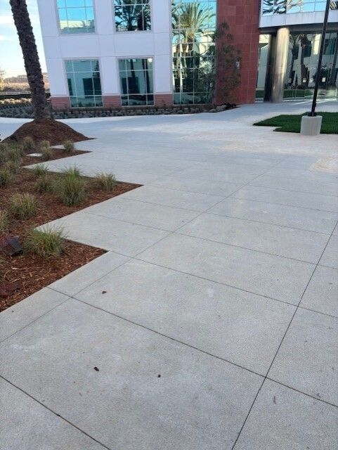 A concrete walkway in front of a large building