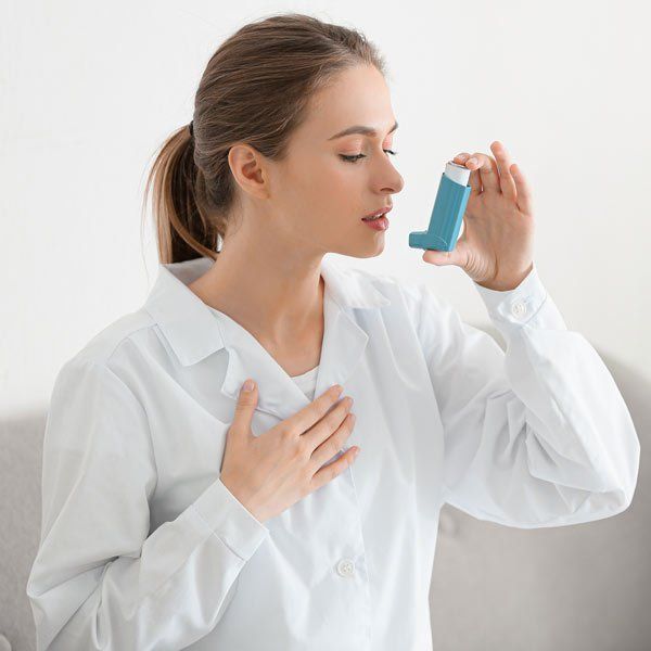 Woman with Asthma using an inhaler