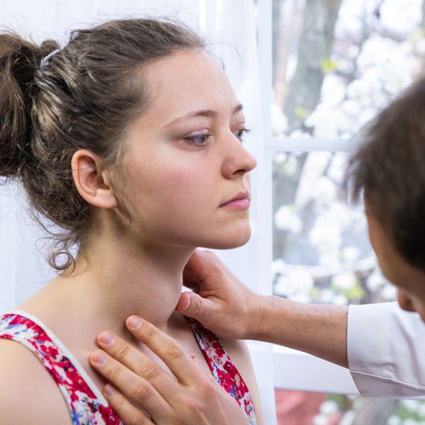 Doctor examining patients with Hyperthyroidism