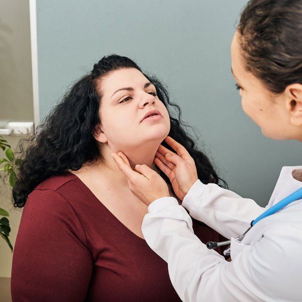 Female doctor exanimating patient with Hypothyroidism