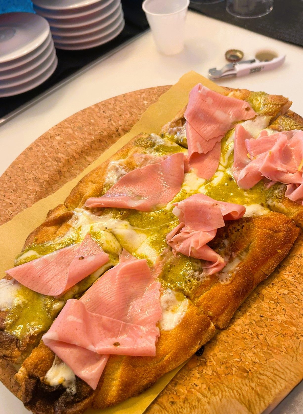 Tavolo da pranzo con quattro sedie bianche. Il tavolo è marrone, con una piccola pianta e oggetti al centro.