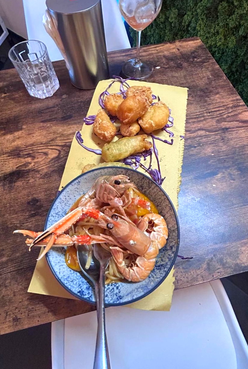 Pizza piatta con salsa, formaggio e basilico, accanto a una confezione di salame.