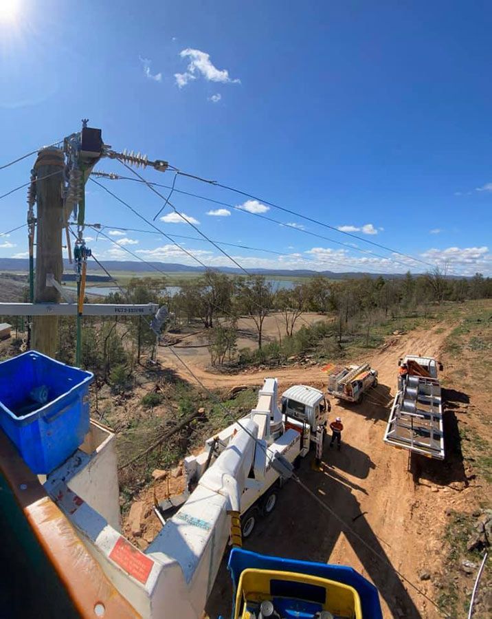 A group of trucks are parked on the side of a dirt road — Country Powerline Constructions in Dubbo, NSW