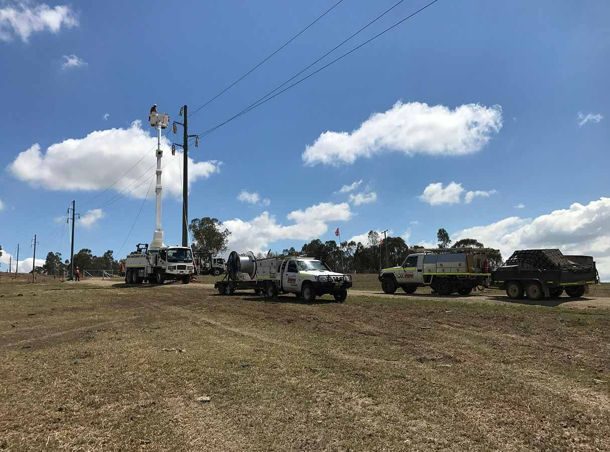 A Group of Trucks Are Parked in a Field Next to Power Lines — Country Powerline Constructions in Dubbo, NSW