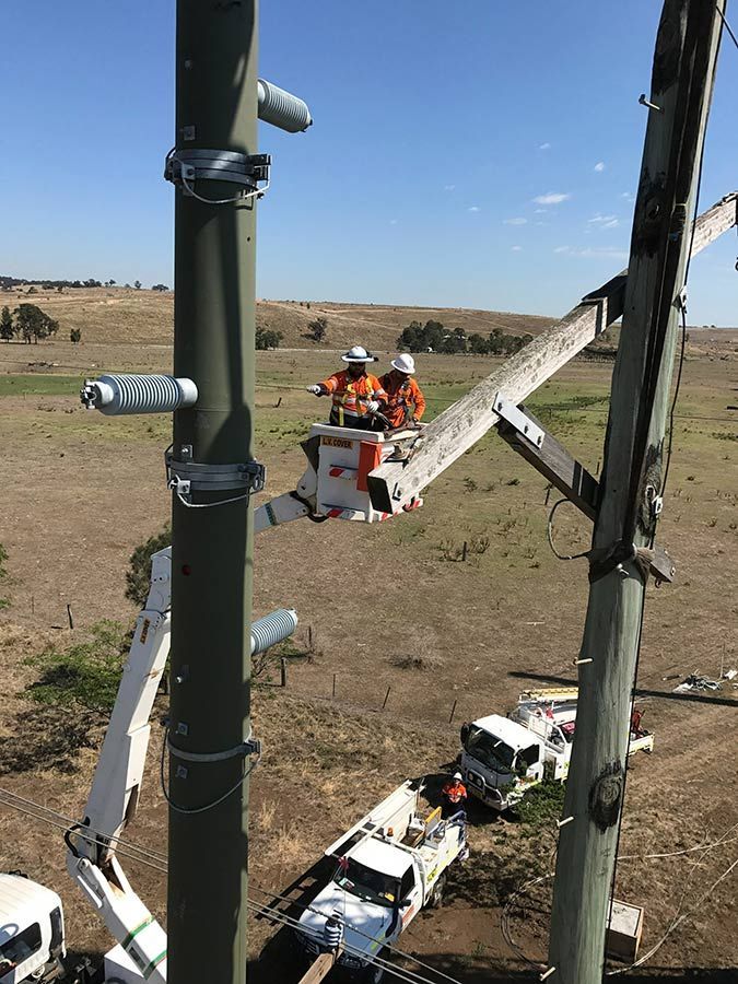 Two Men Are Working on a Pole With a Crane — Country Powerline Constructions in Dubbo, NSW