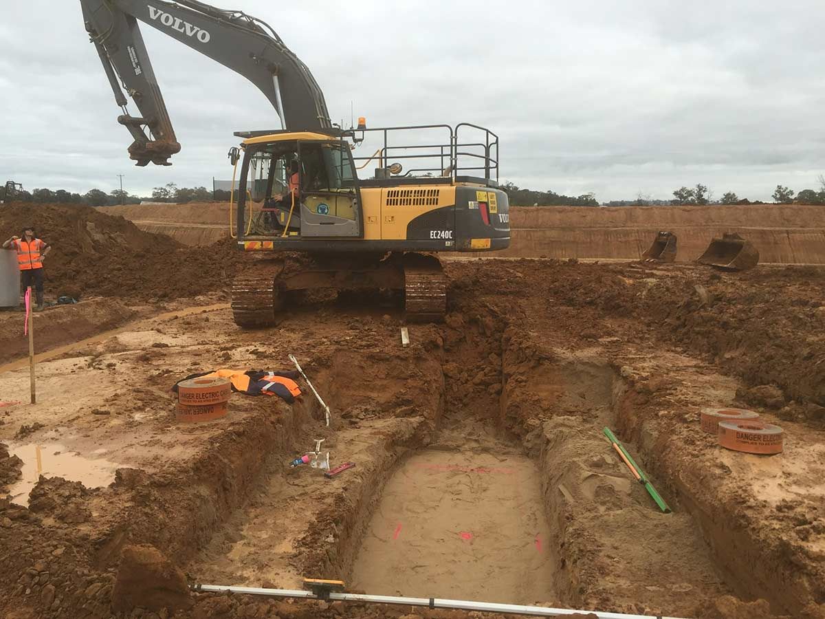 A Volvo Excavator is Digging a Hole in the Dirt — Country Powerline Constructions in Dubbo, NSW