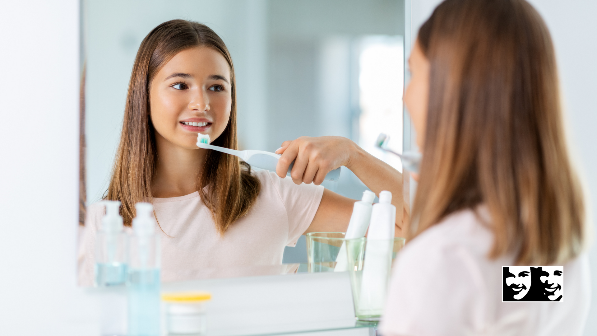 A woman is brushing her teeth in front of a mirror.