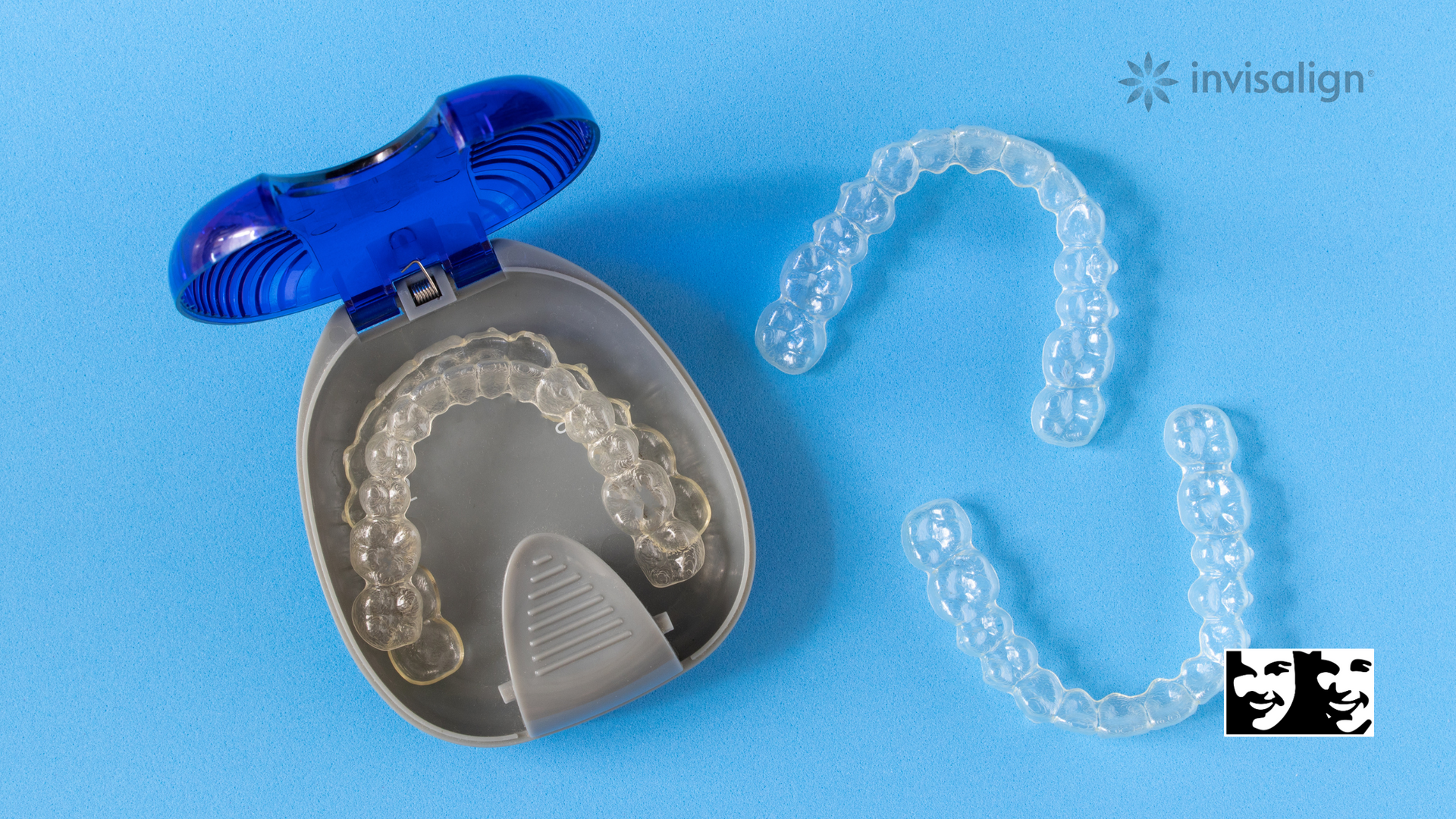 A pair of invisalign aligners in a case on a blue surface.