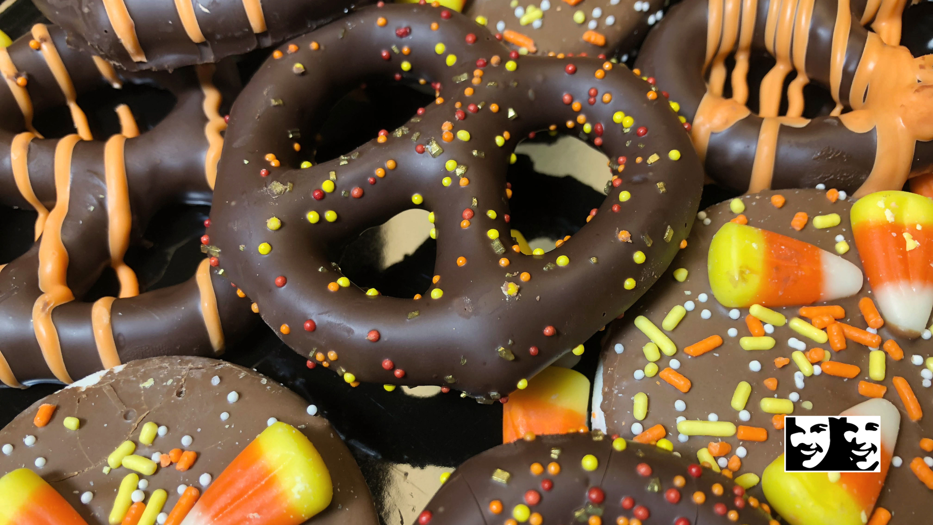 Chocolate-covered pretzels and cookies with fall-colored sprinkles and candy corn.