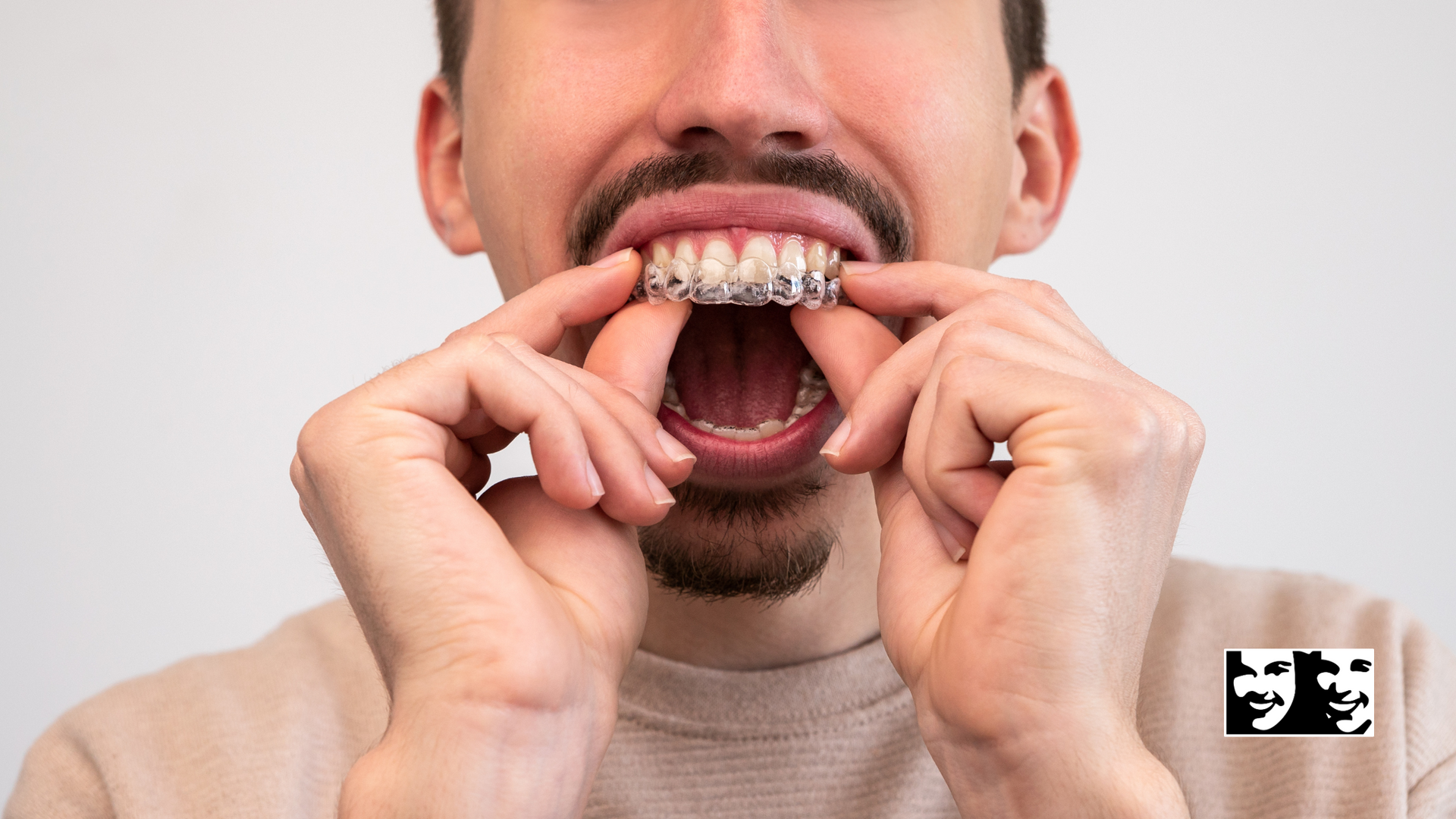 A man with braces on his teeth is holding his mouth open.