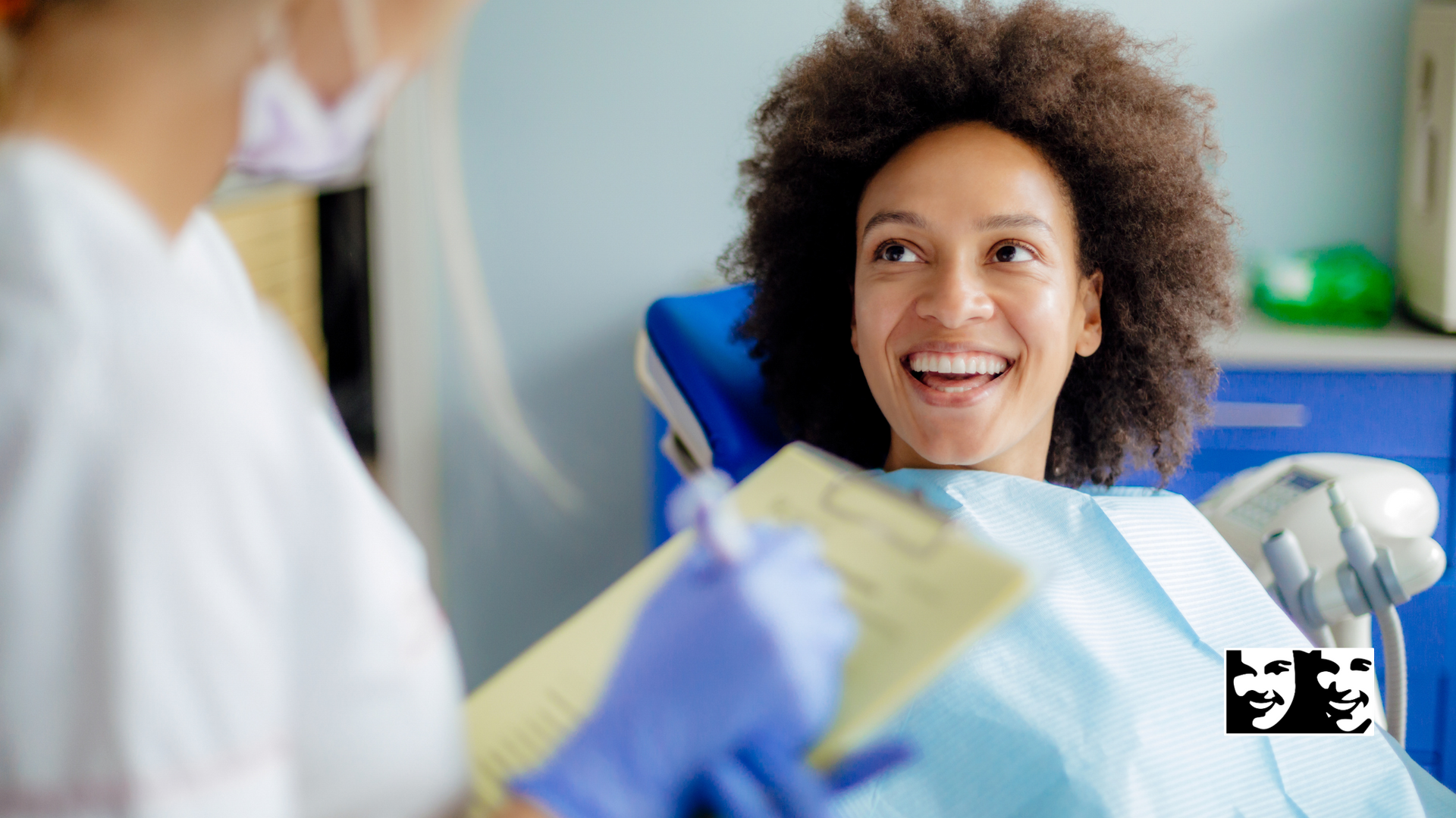 A woman is smiling while sitting in a dental chair.