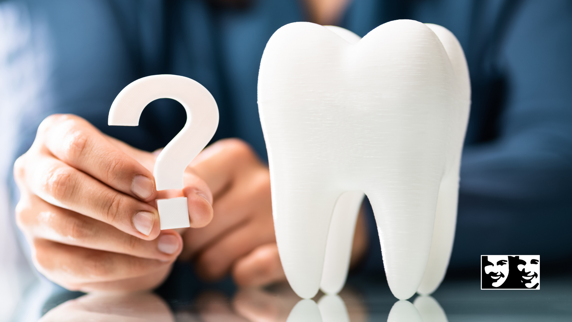 A person is holding a question mark next to a tooth