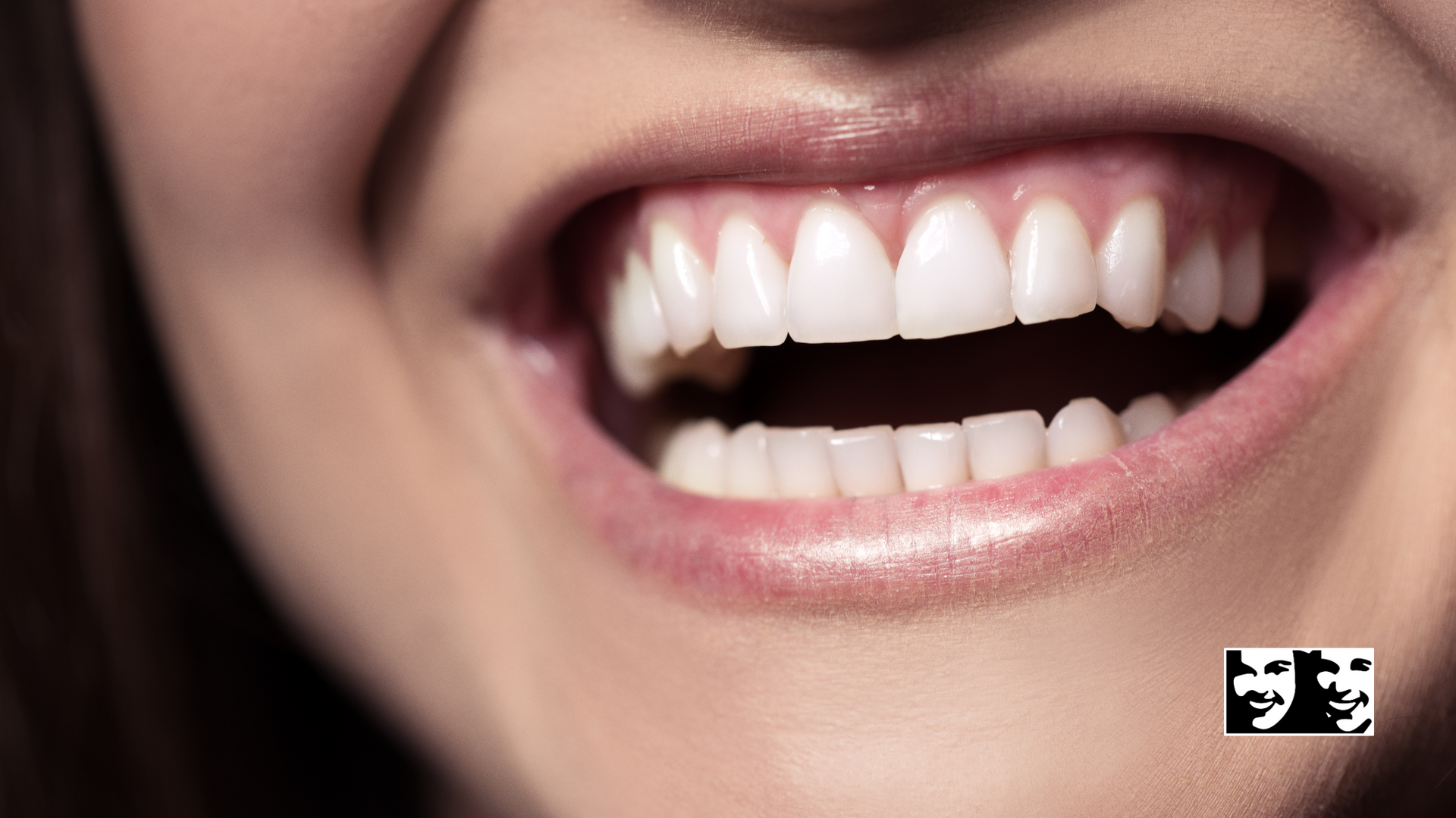 A close up of a woman 's mouth with her teeth showing.