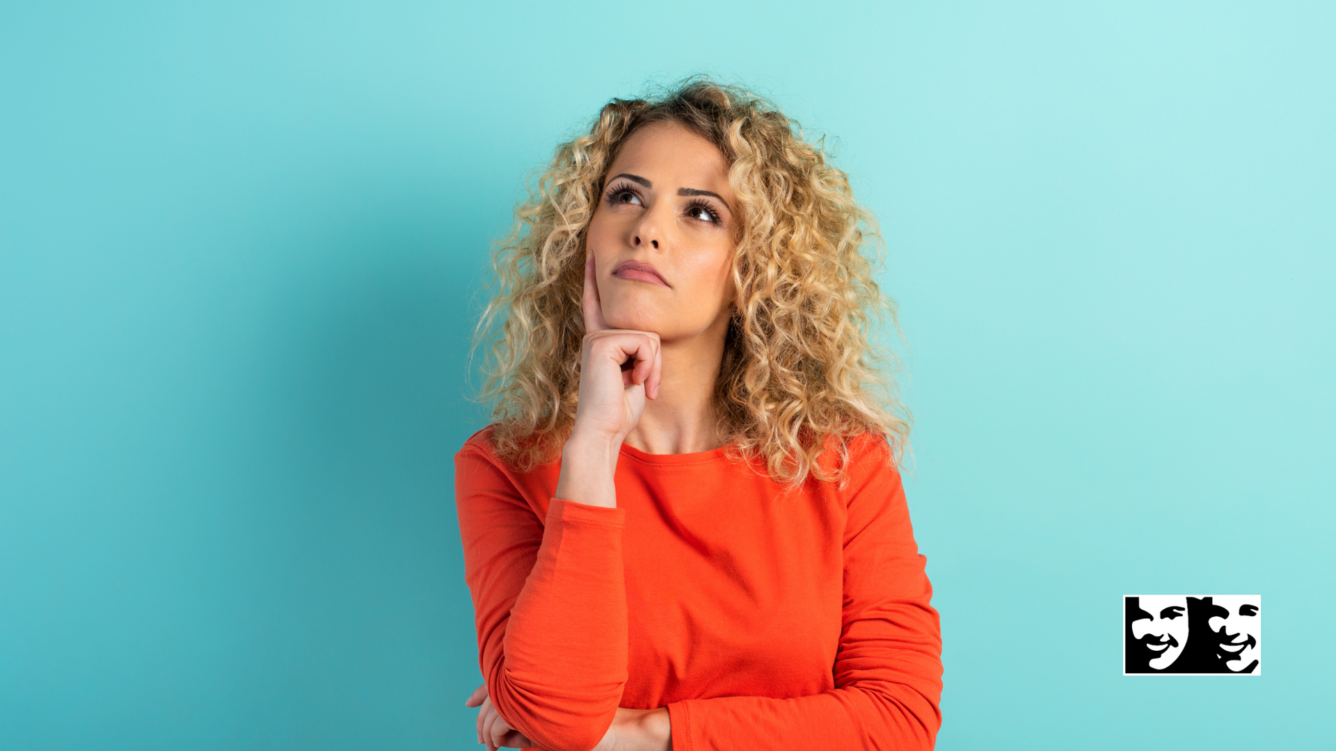 A woman with curly hair is wearing a red shirt and looking up.