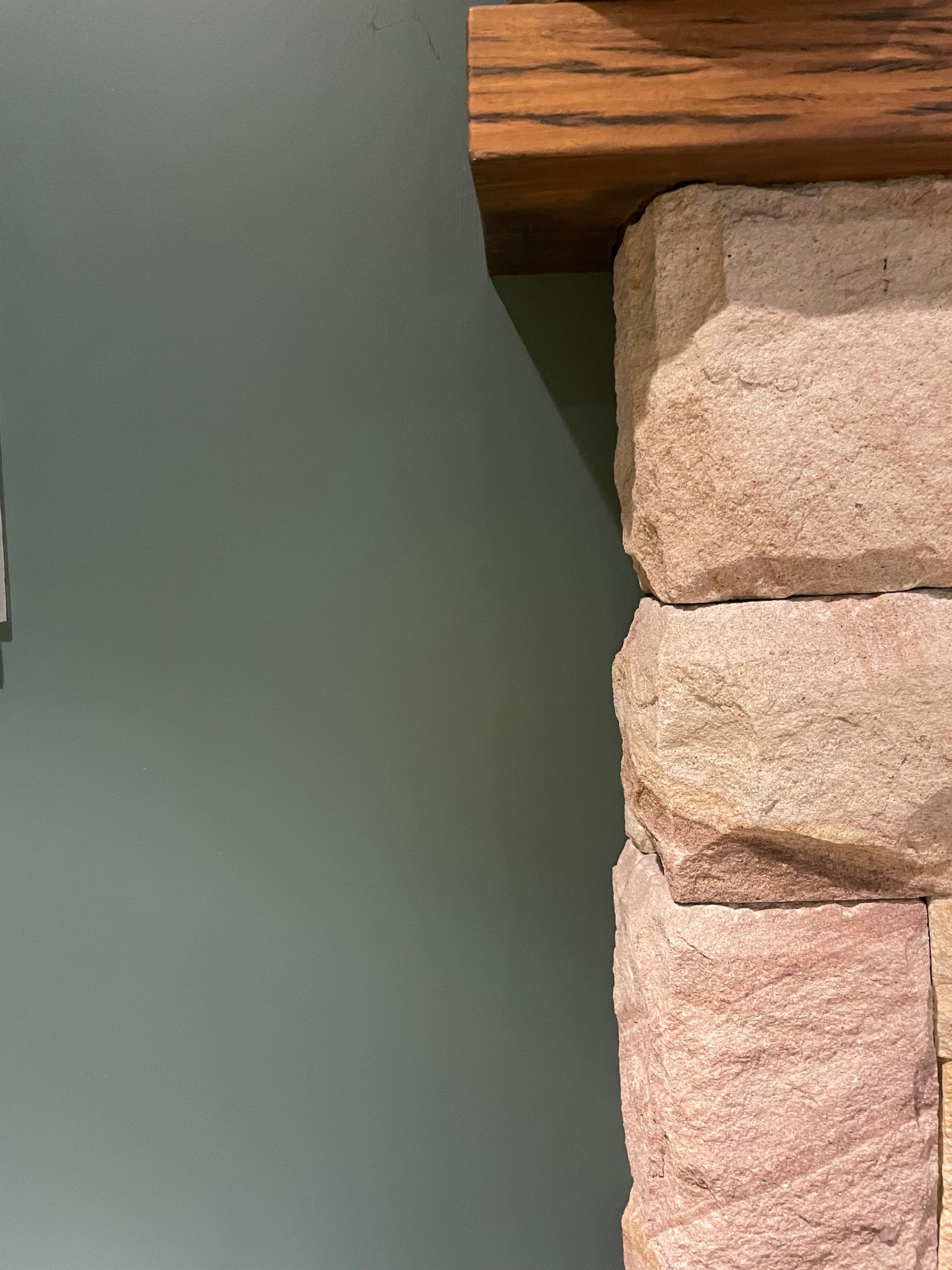 A close up of a stone fireplace with a wooden mantle — Timeless Painting In Umina Beach, NSW