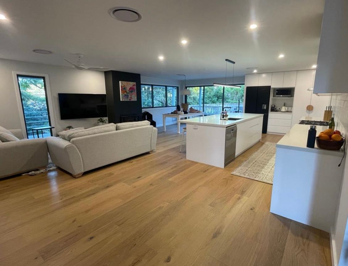 A living room and kitchen in a house with hardwood floors — Timeless Painting In Umina Beach, NSW