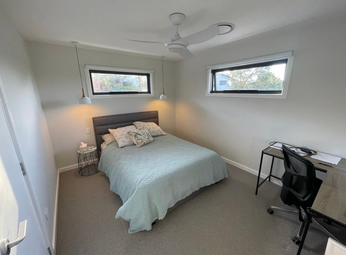 A bedroom with a bed , desk , chair and ceiling fan — Timeless Painting In Umina Beach, NSW