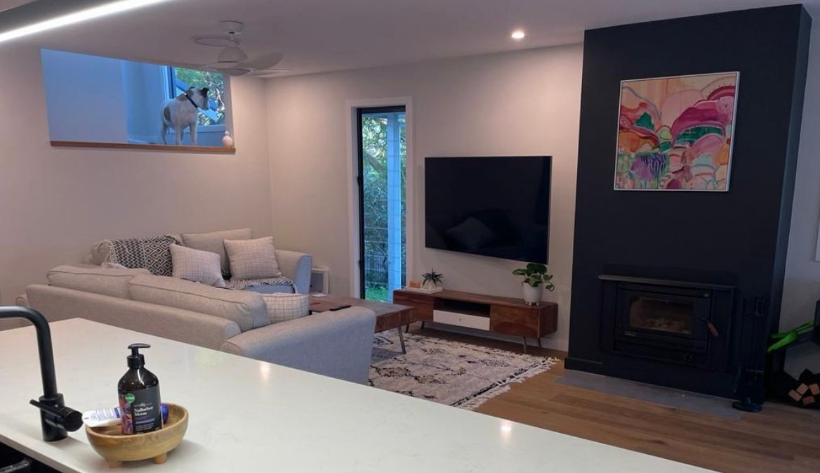 A living room with a couch , fireplace and television — Timeless Painting In Umina Beach, NSW