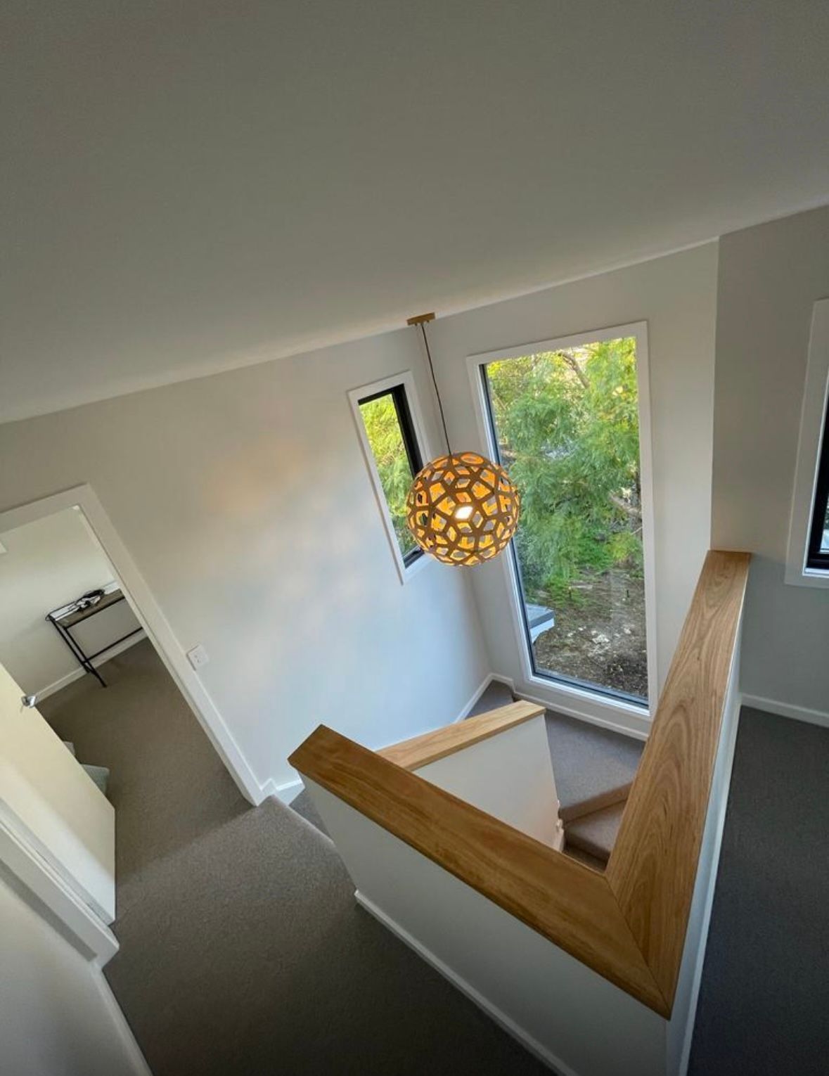 A staircase with a wooden railing and a light hanging from the ceiling — Timeless Painting In Umina Beach, NSW