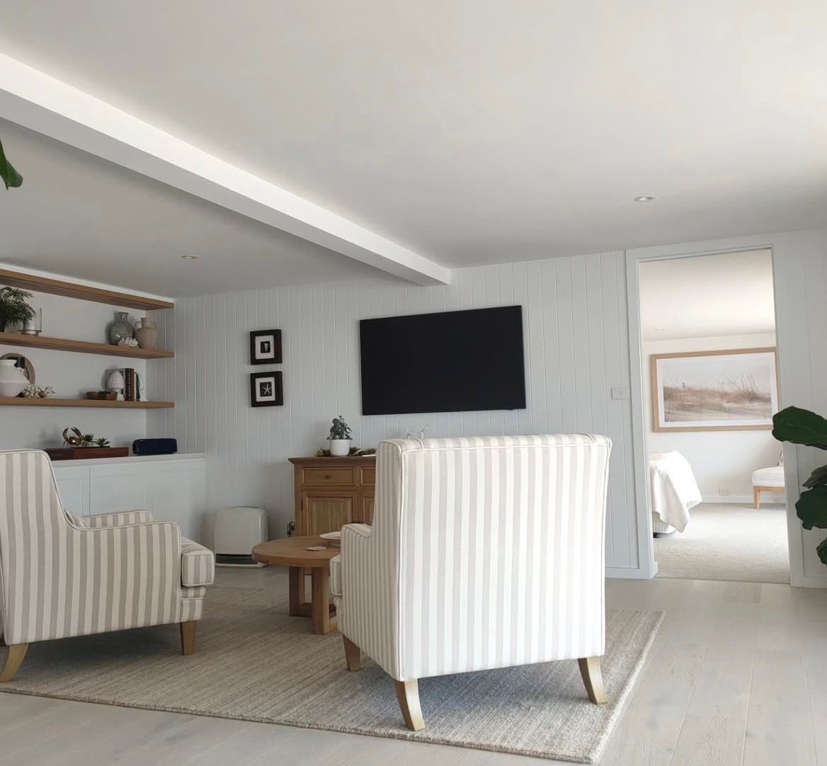 A living room with striped chairs and a flat screen tv — Timeless Painting In Umina Beach, NSW