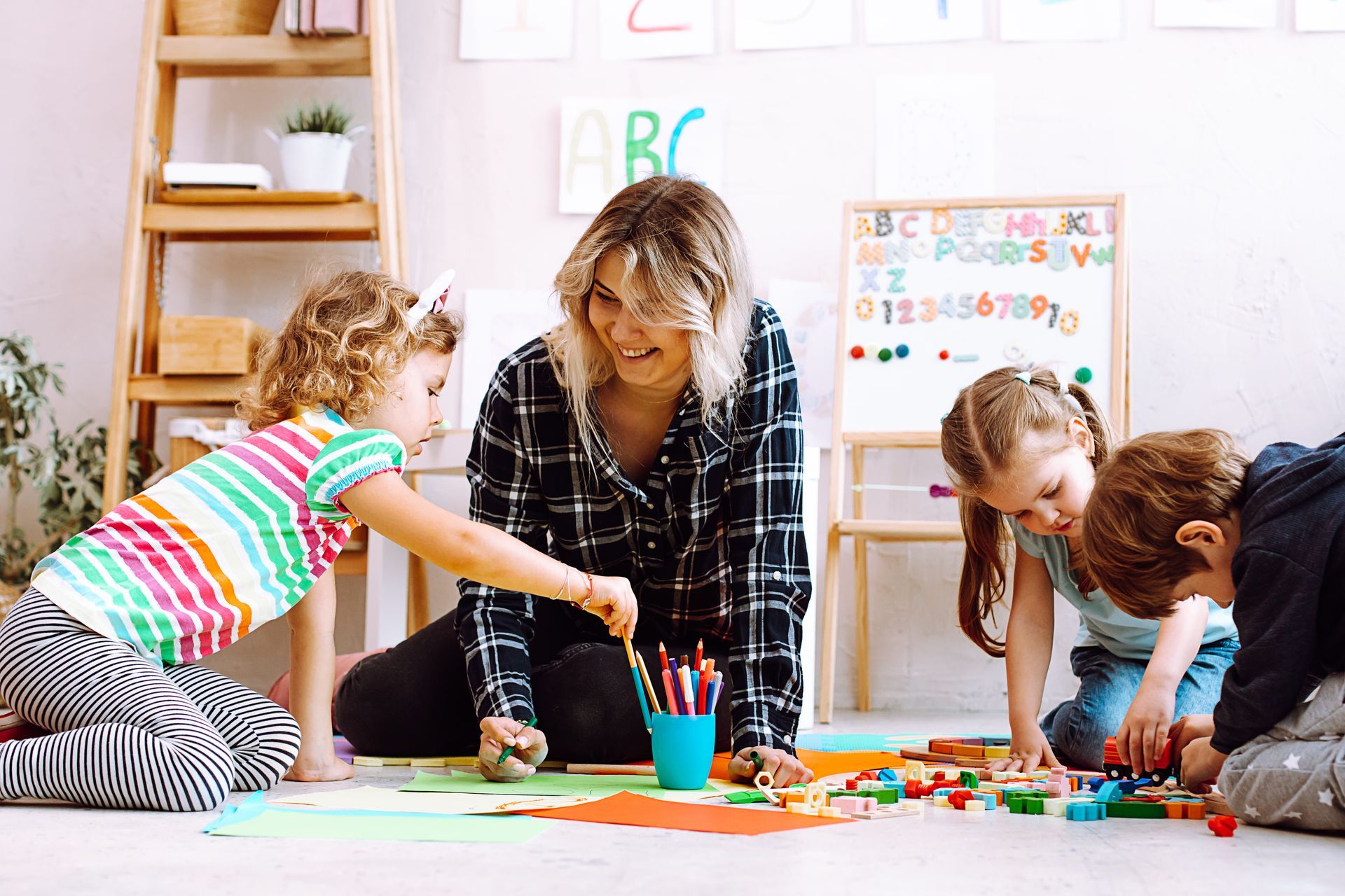 Early Childhood Education classroom with a teacher guiding children in hands-on learning activities.