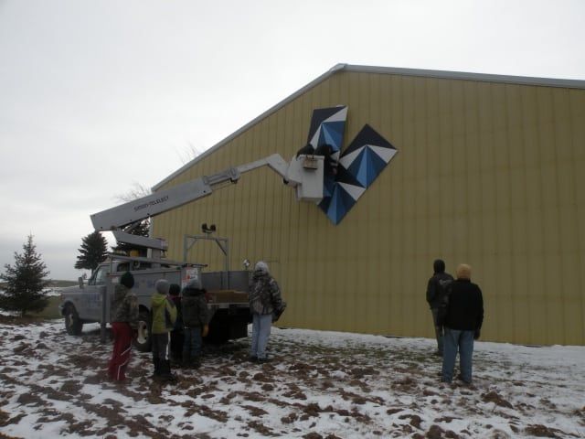 Electricians Fixing Signage on Beige Wall House — Shawano, WI — Raddant Electric Service Inc