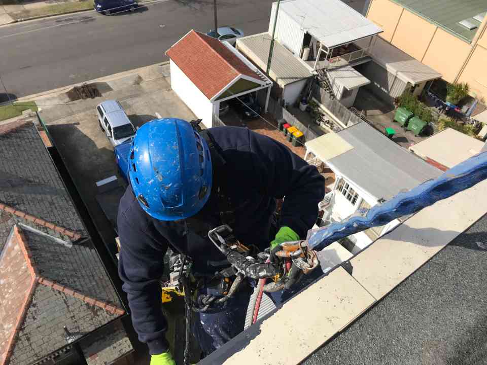worker using rope to climb down