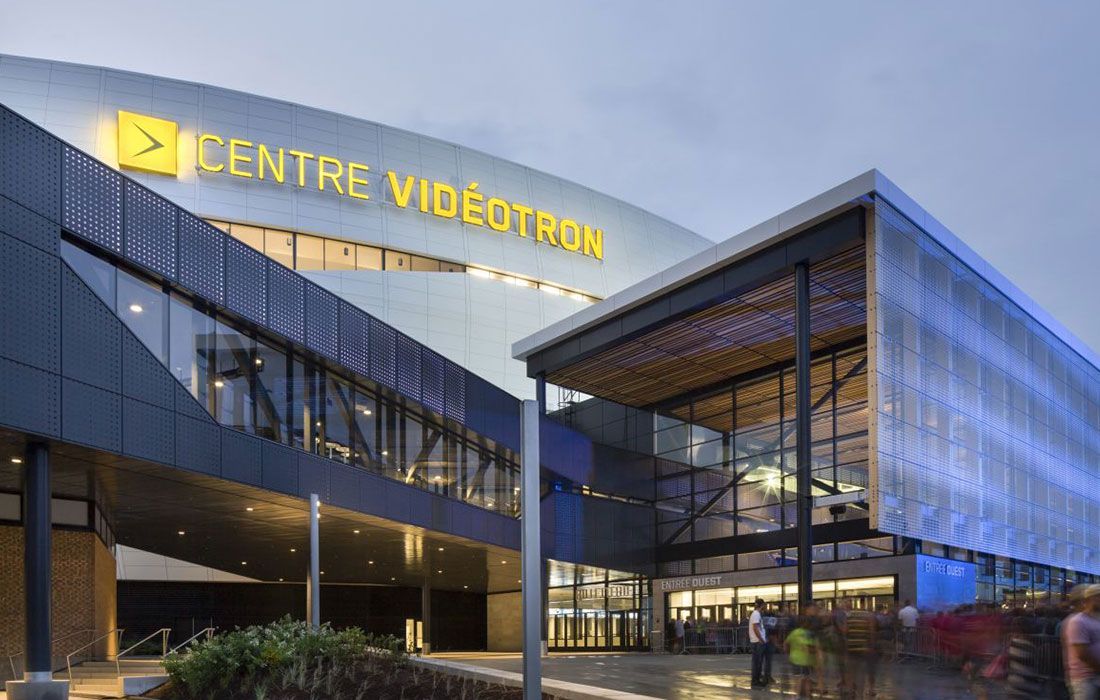 Vue extérieure de l'aréna du Centre Vidéotron, Québec. Bâtiment moderne à la façade bleue et grise, avec enseigne lumineuse.