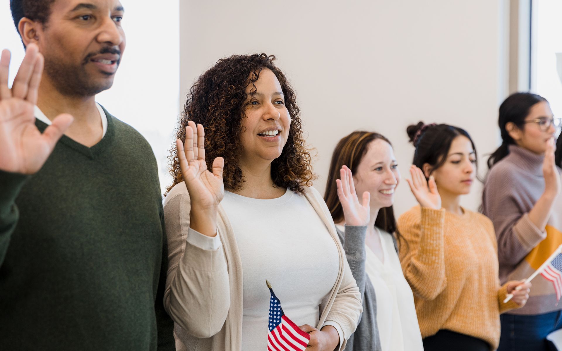A group of people are standing in a line with their hands up.