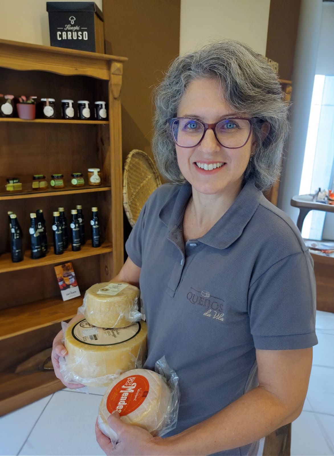 Uma mulher está segurando dois pedaços de queijo nas mãos.