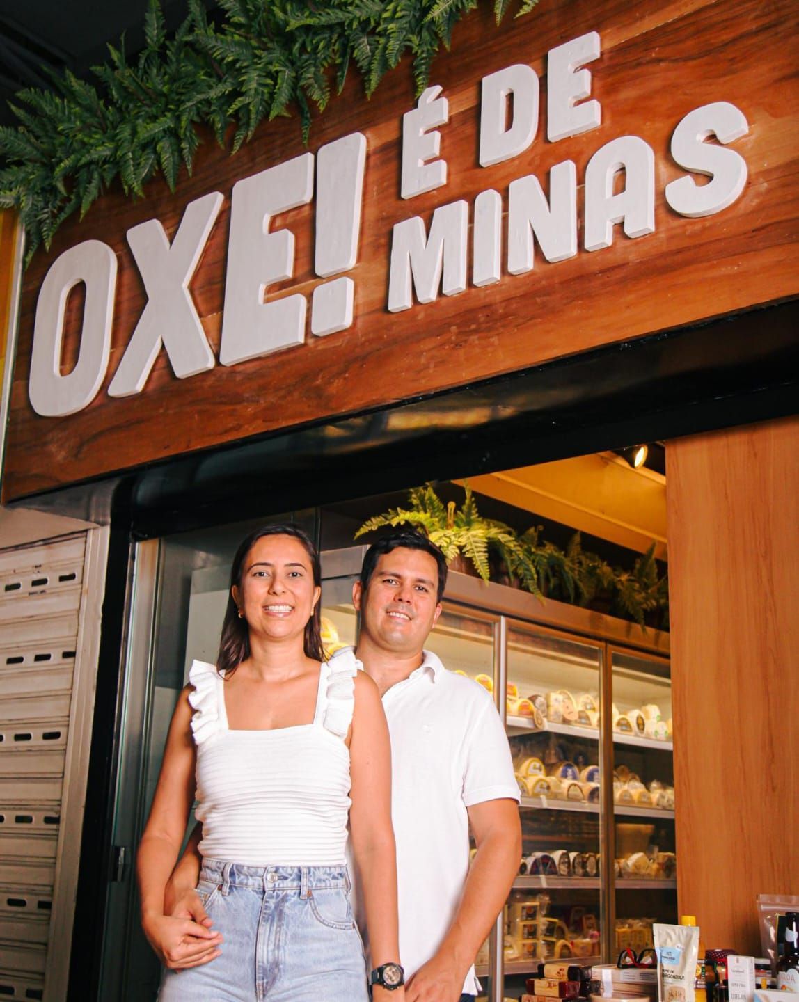 Um homem e uma mulher estão em frente a uma loja chamada oxe e de minas