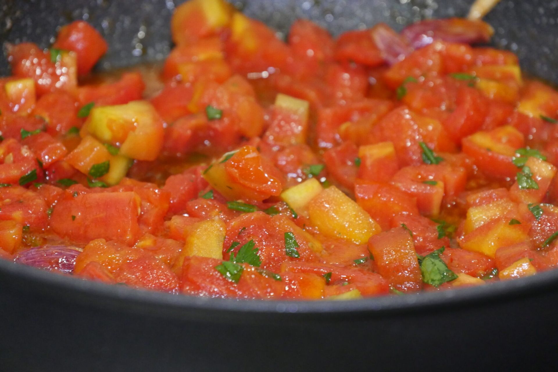 un primo piano di una padella piena di pomodori e peperoni .