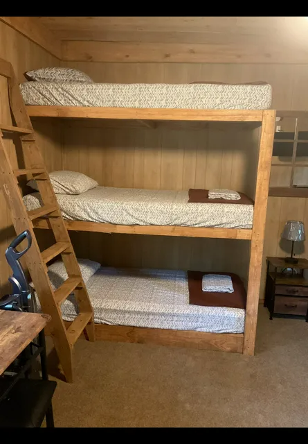 Wooden bunk beds with patterned bedding in a small cabin room