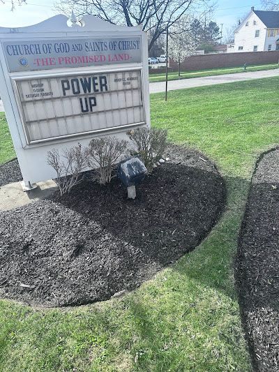 A sign that says `` power up '' is sitting in the middle of a lush green field.