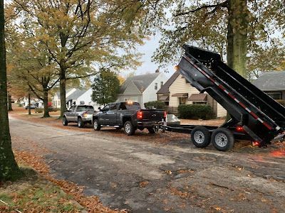 A dump truck is pulling a trailer down a street.