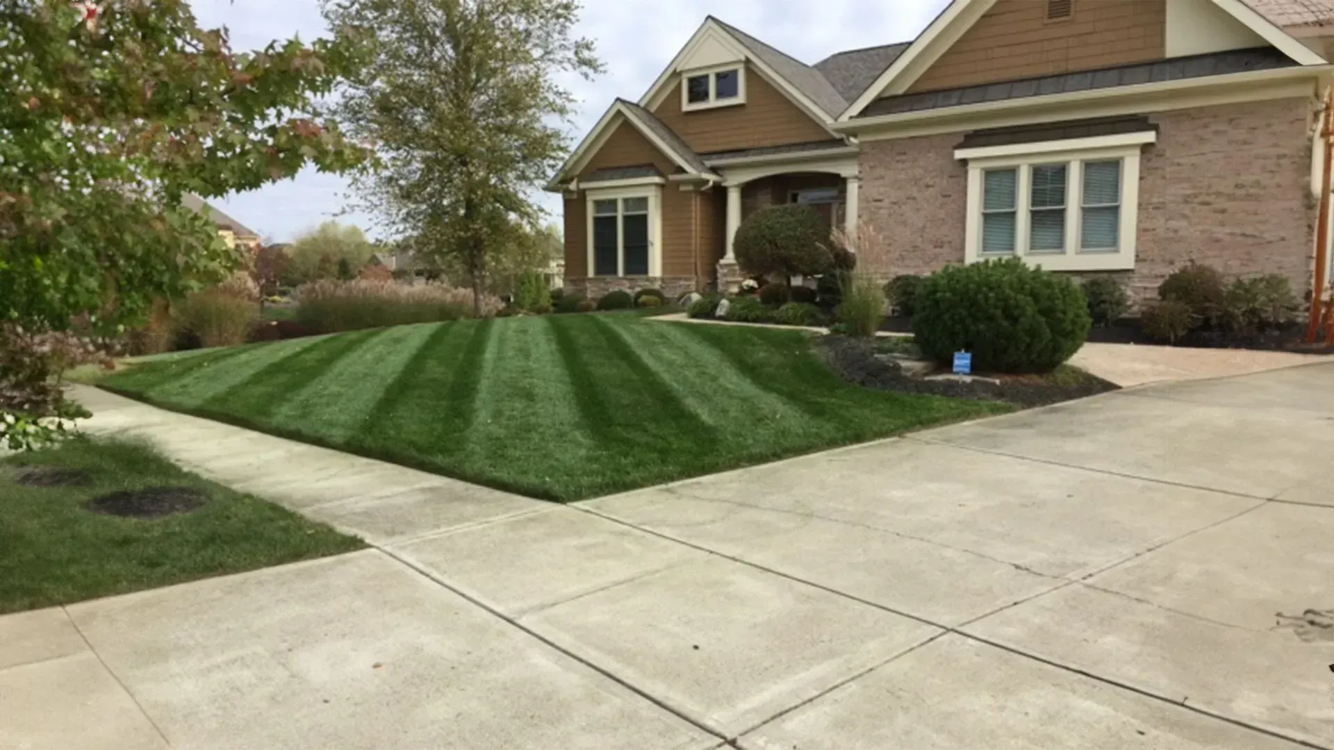 A brick house with a lush green lawn in front of it.