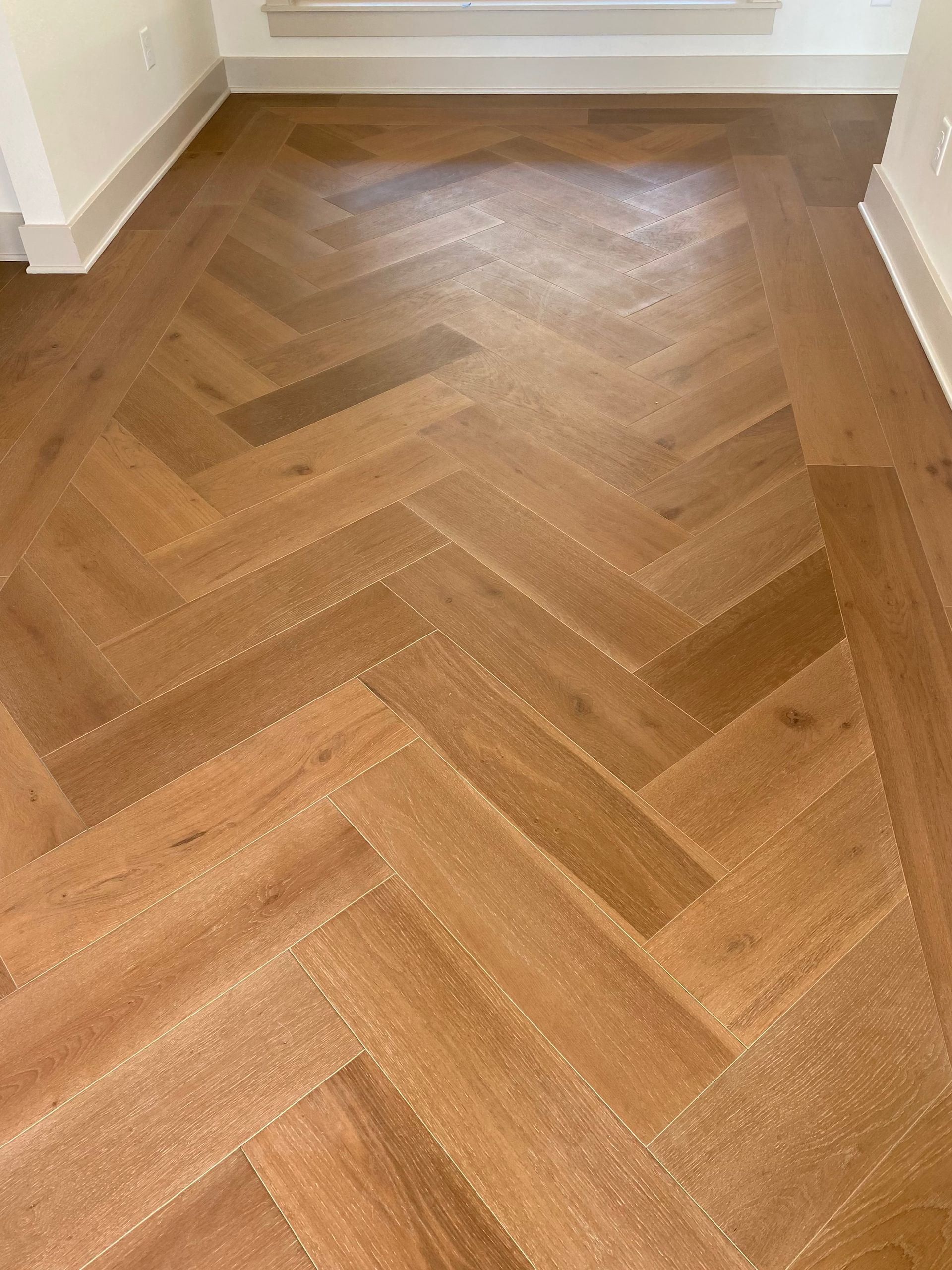 Timeless herringbone layout of engineered hardwood done by our expert installers at Zwernemann.