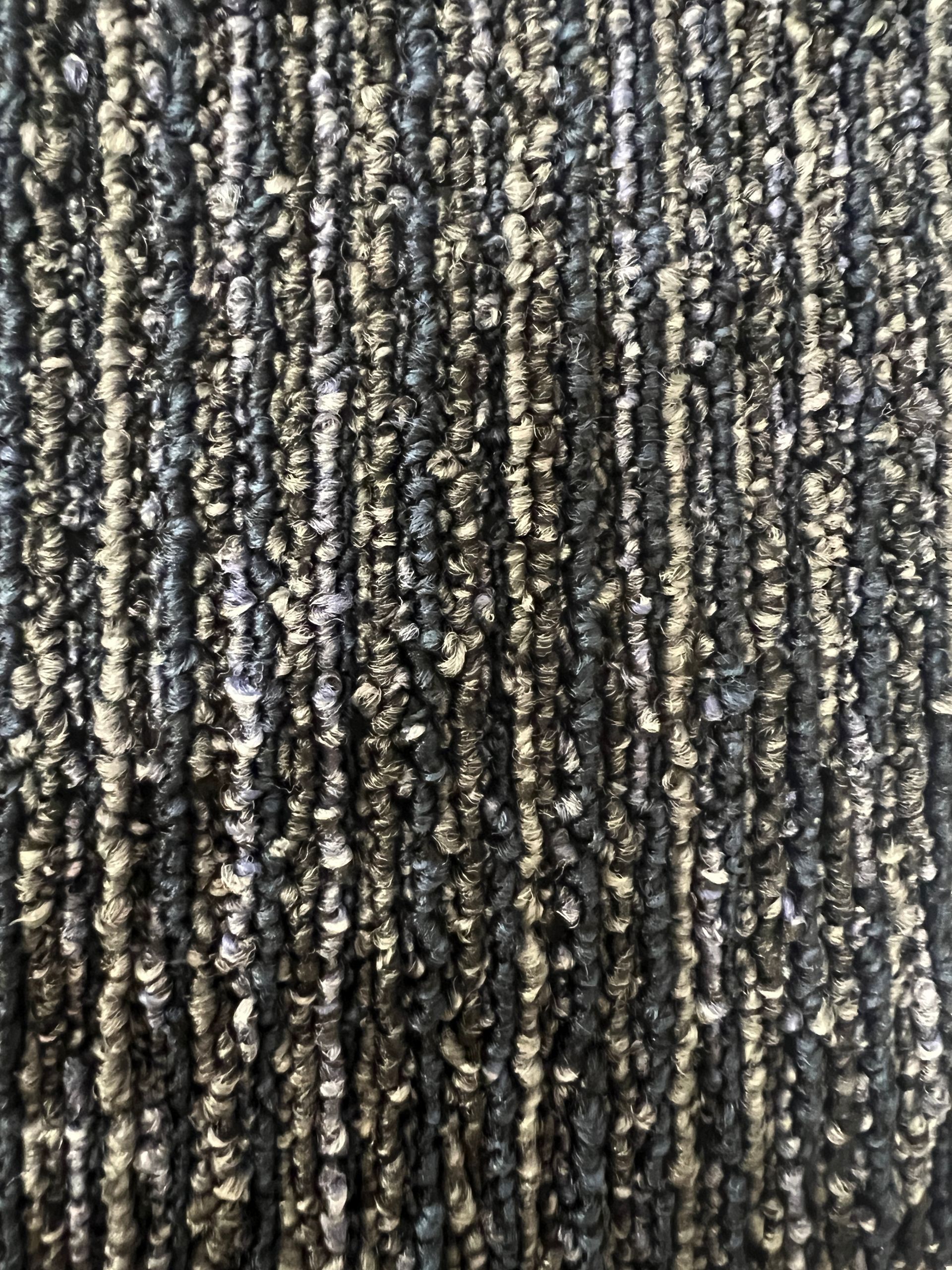 Textured carpet in vertical black and gray stripes.
