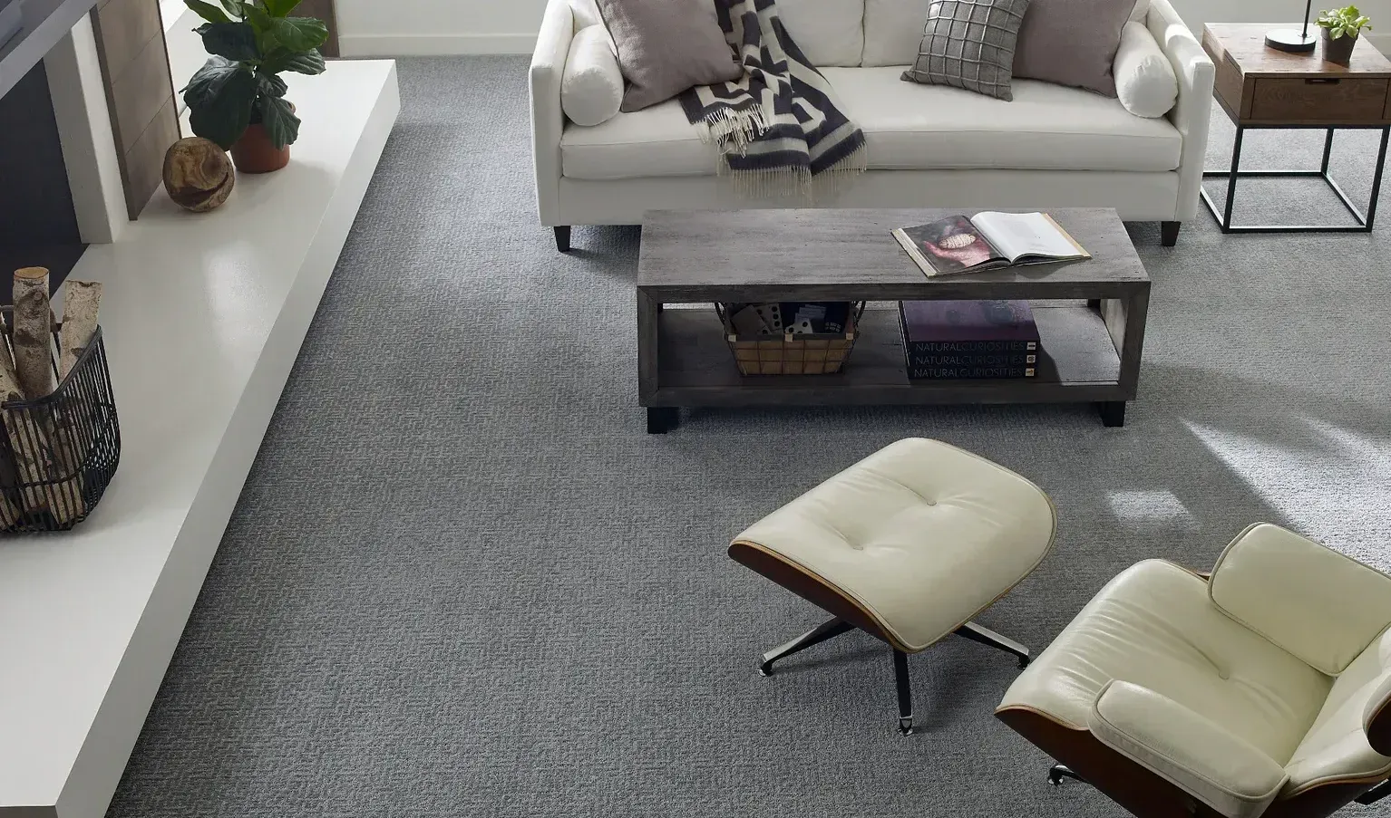 A living room with a couch , chair , coffee table and fireplace.