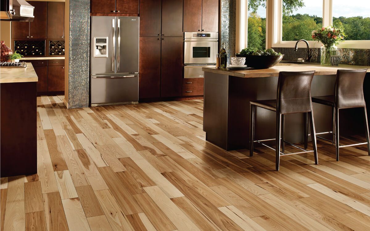 A kitchen with hardwood floors and a stainless steel refrigerator