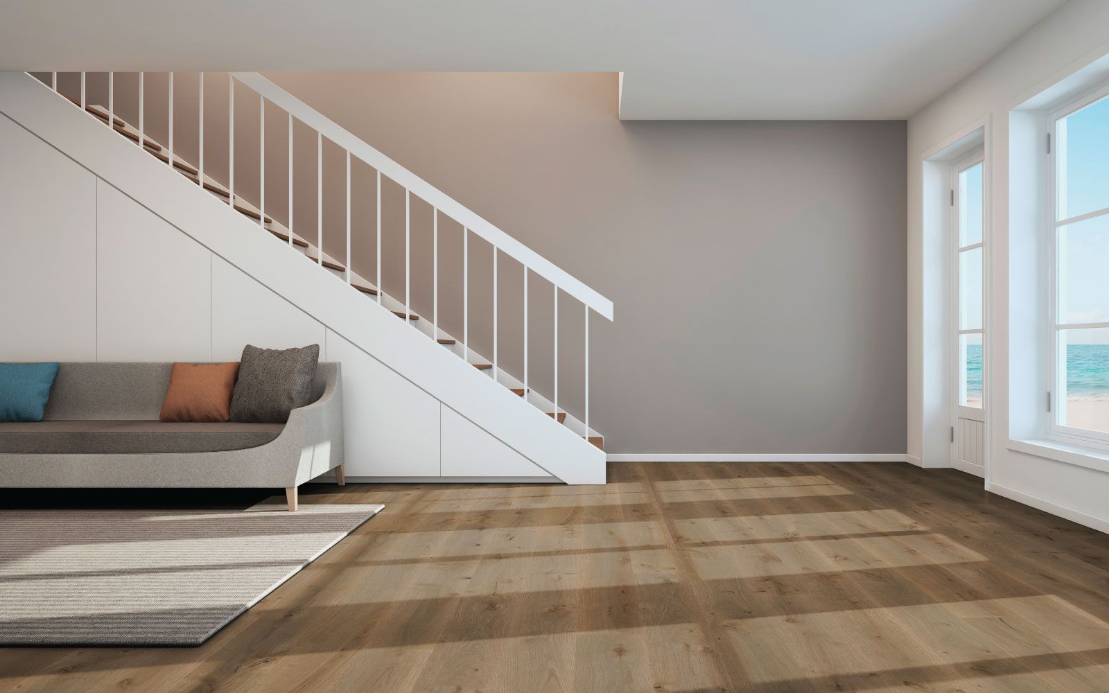 An empty living room with a staircase and a couch.