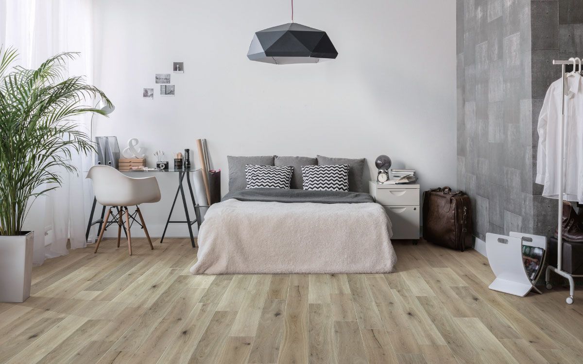 A bedroom with hardwood floors and a large bed.