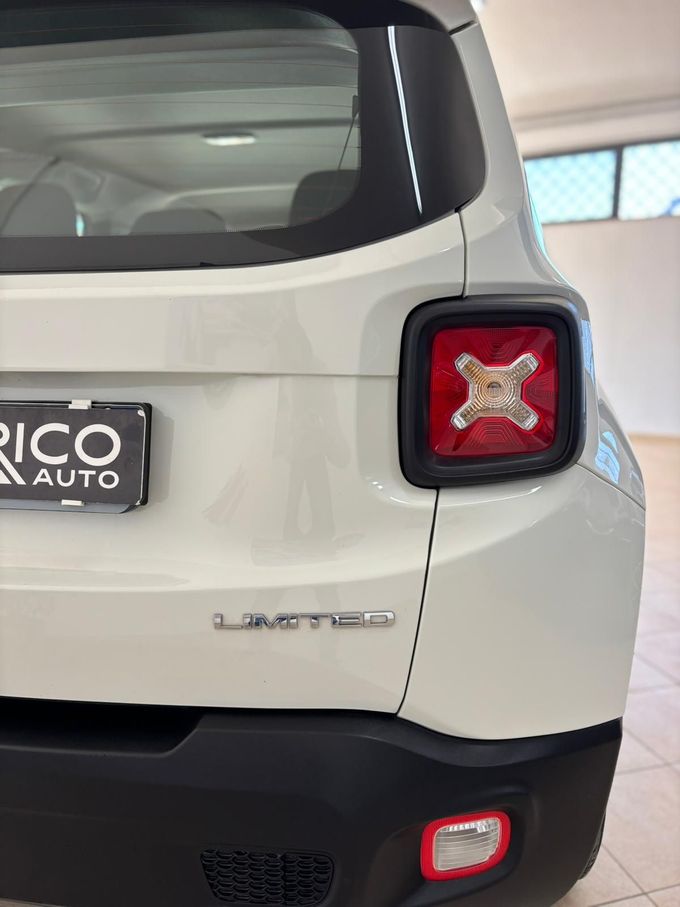 Parte posteriore di un'auto compatta bianca con paraurti nero e fanali posteriori rossi, parcheggiata al chiuso.