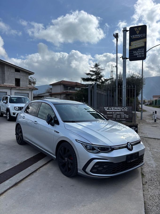 Primo piano della griglia anteriore e del cofano di una Jeep grigia in uno showroom.